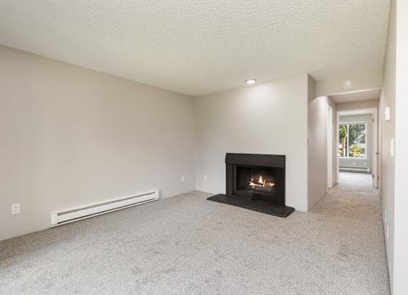 A living room with a fireplace and a carpet in our 1 bedroom apartment at Hillcrest.