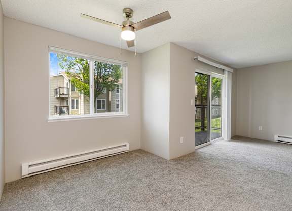 A Dining/Living space with a ceiling fan and a window.