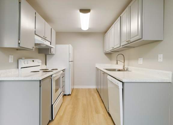 A kitchen with white appliances and cabinets.