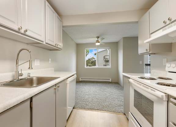 A kitchen with white cabinets and a stove top oven.