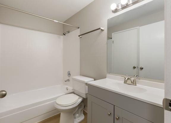 A bathroom with a toilet, sink, and bathtub.