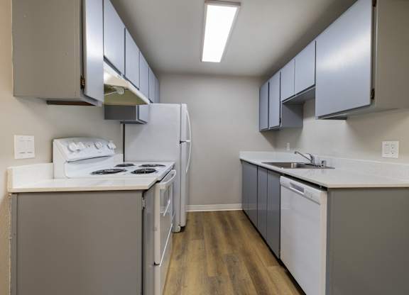 A kitchen with white appliances and grey cabinets.