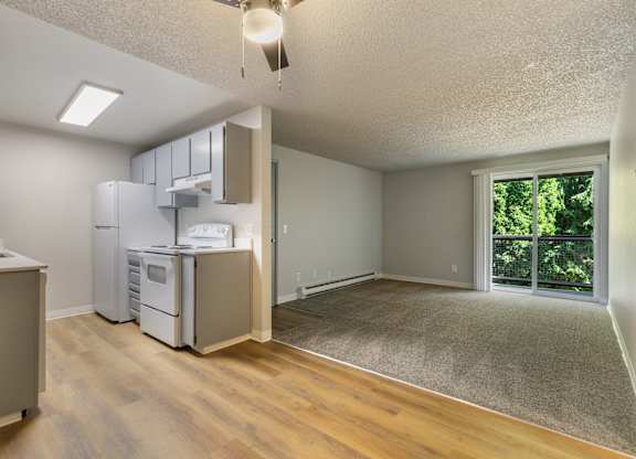A kitchen with a refrigerator, microwave, and oven.