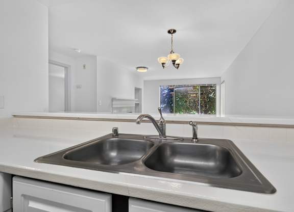 A modern kitchen with a double sink and a window.