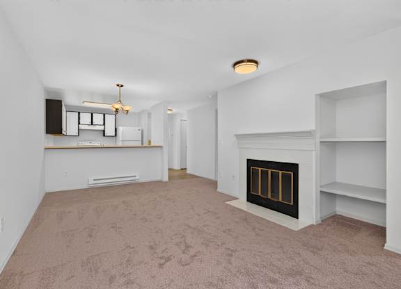 A living room with a fireplace and a carpet on the floor.