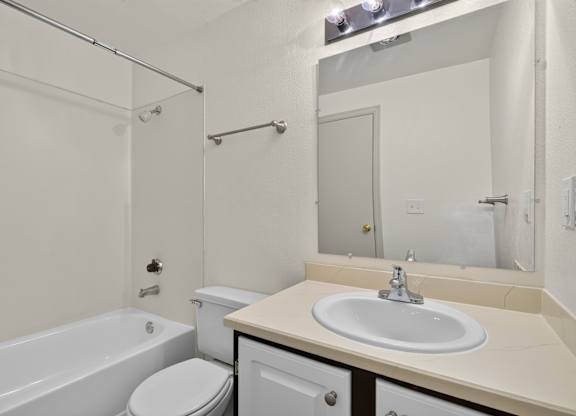A white bathroom with a sink, toilet, and bathtub.