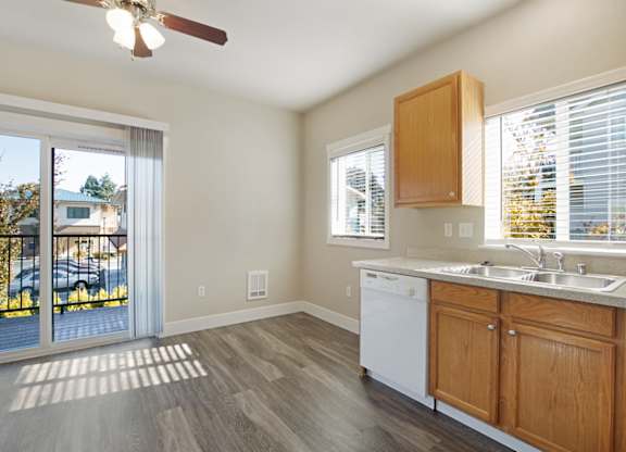 Kitchen with oak cabinets and light color countertops and wood plank vinyl flooring at Hearthstone Apartments