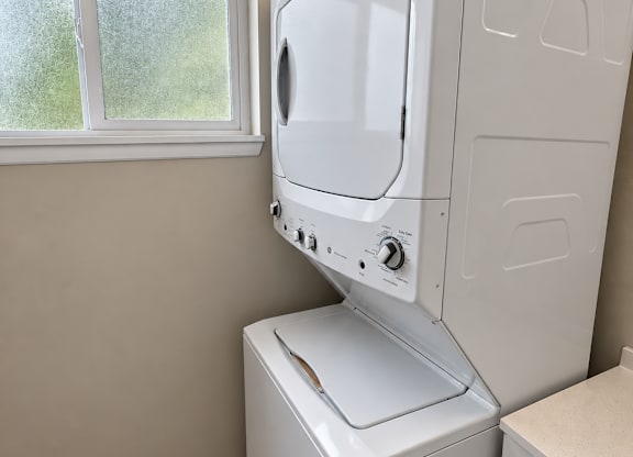 A white washing machine and dryer in a laundry room.