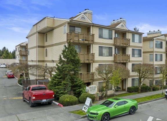 an apartment building with cars parked in front of it