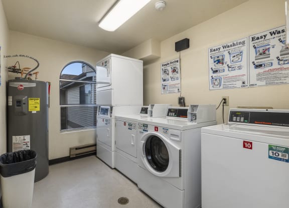 a laundry room with four washing machines and a washer and dryer