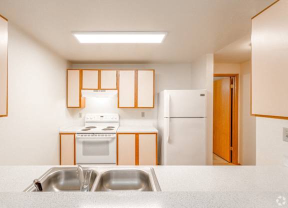 A kitchen with a white counter top and a sink.