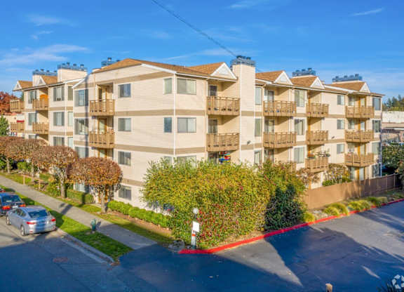 Apartment building with cars parked in front.