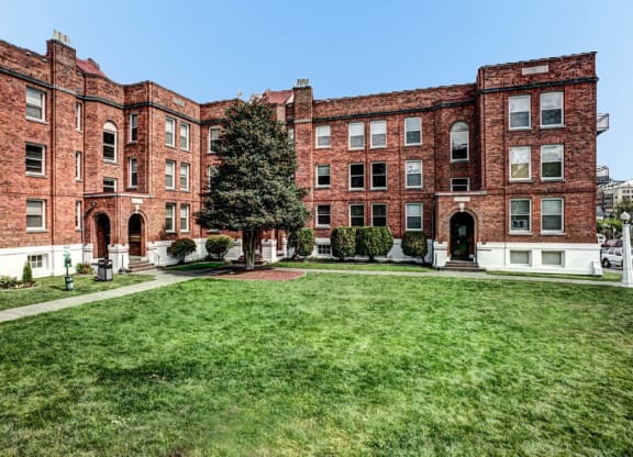 a large red brick building with a lawn in front of it