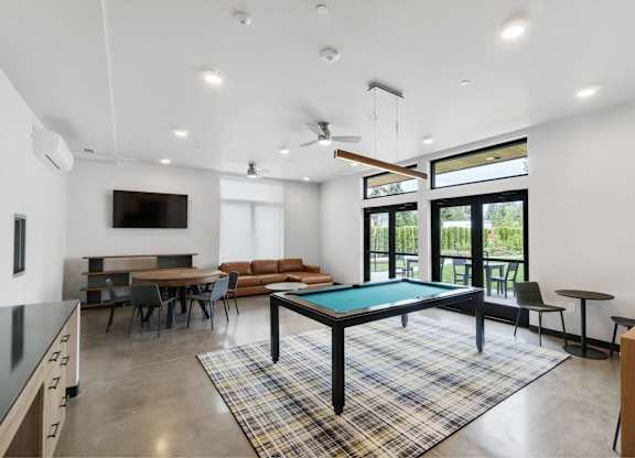 A room with a pool table and a television at The Hub Apartments, Lacey, WA