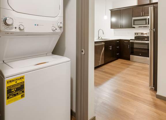 A white dishwasher with a yellow sticker on it is in a kitchen.
