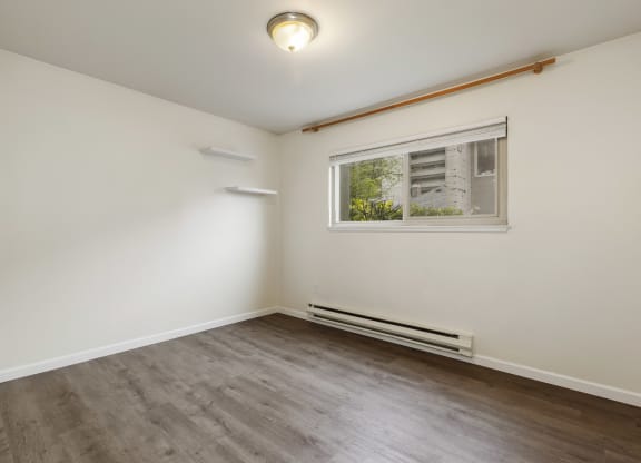 a living room with white walls and a window