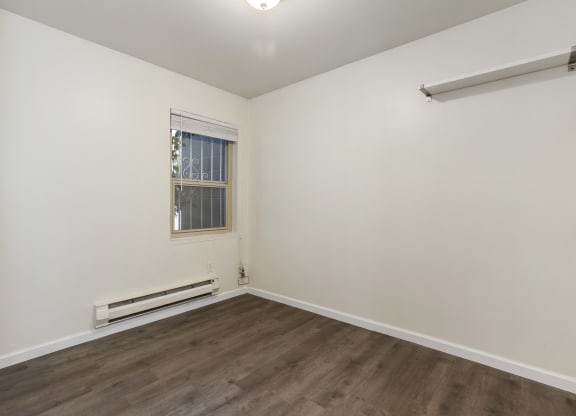 an empty room with white walls and a window