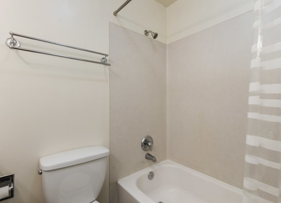 a bathroom with a toilet and a tub and a shower curtain