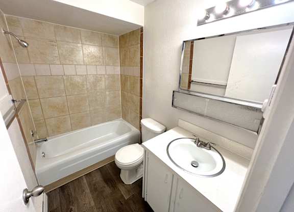 A white bathroom with a toilet, sink, and bathtub.