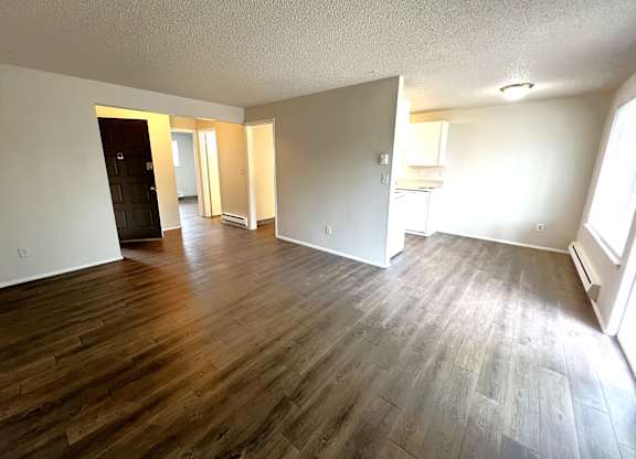 A room with wooden flooring and white walls.