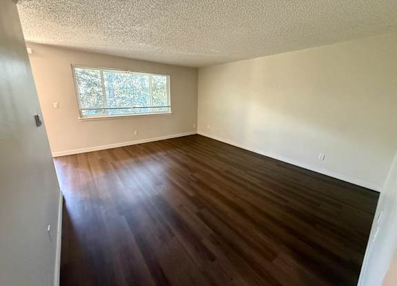 A room with wooden floors and a window.