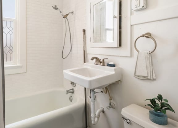 a white bathroom with a sink and a bath tub