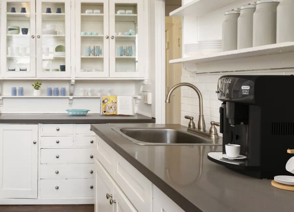 a kitchen with white cabinets and a sink and a refrigerator