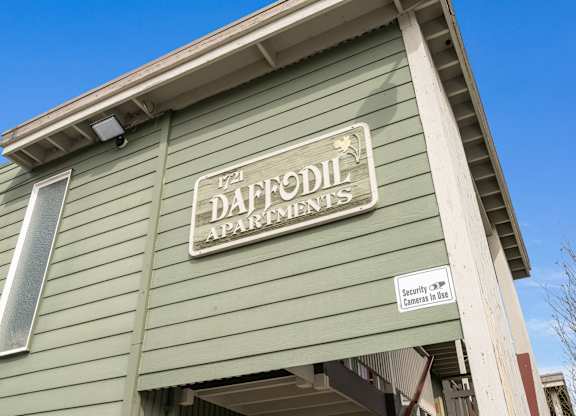 A green building with a sign that says Daffodil Apartments.