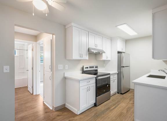 A kitchen with white cabinets and appliances.