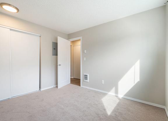 A room with a carpeted floor and a white door.