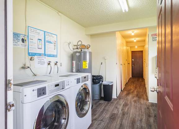 A laundry room with washers and dryers and a sign on the wall.
