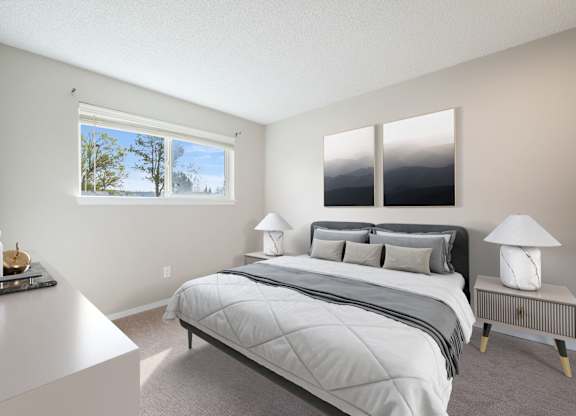 A bedroom with a large bed and a window overlooking a body of water.