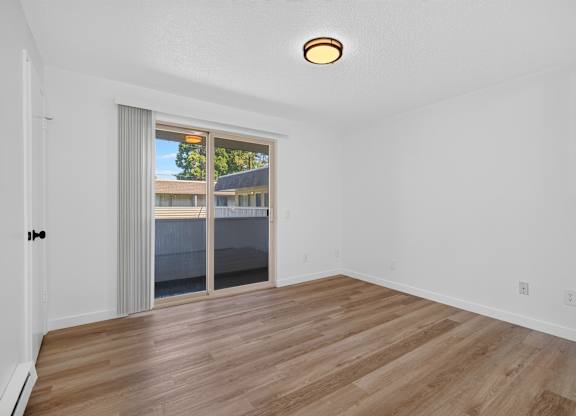 A room with a sliding glass door leading to a balcony.