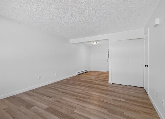 A room with wooden flooring and white walls.