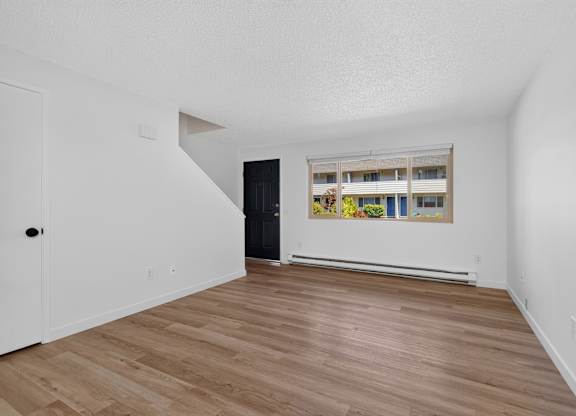 A room with a black door and a painting on the wall.