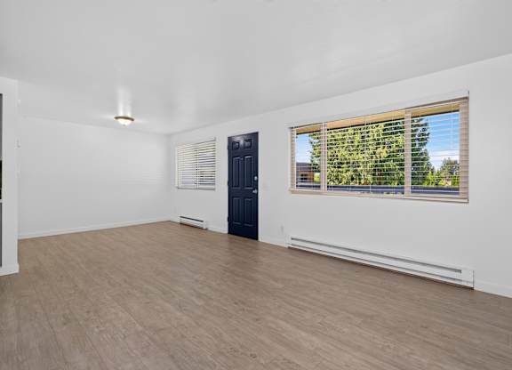 A room with a window showing a view of trees outside.