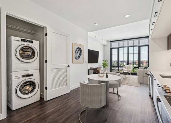A modern laundry room with a washer and dryer built into the cabinetry.