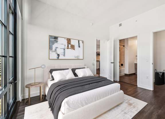 A bedroom with a large bed and a painting on the wall.