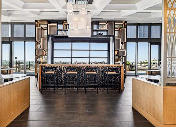 A long table with chairs is in the middle of a room with a large window.