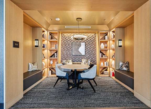 A modern dining room with a round table and chairs.
