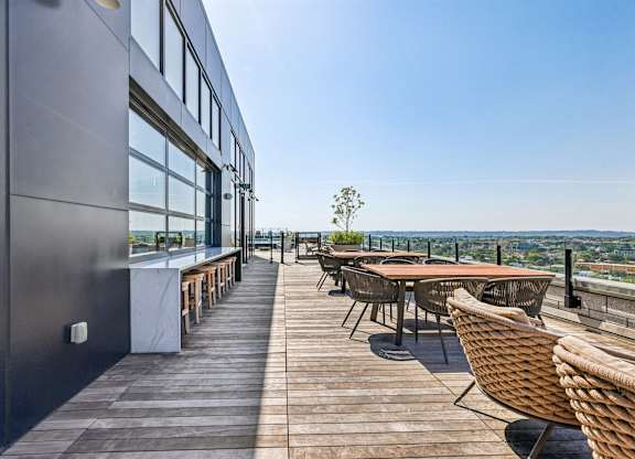 A patio with a table and chairs overlooking a cityscape.