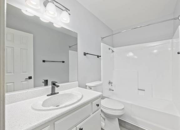 A white bathroom with a sink, toilet, and bathtub.