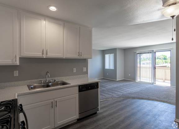 A kitchen with white cabinets and a stove top oven.