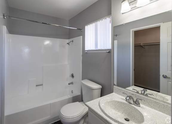 A white toilet sits next to a sink in a bathroom.