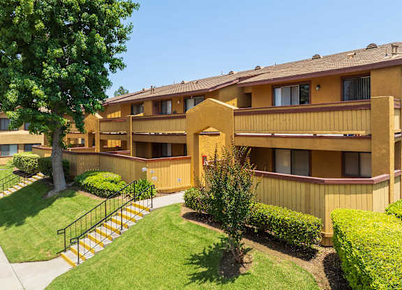 A yellow building with a tree in front of it.