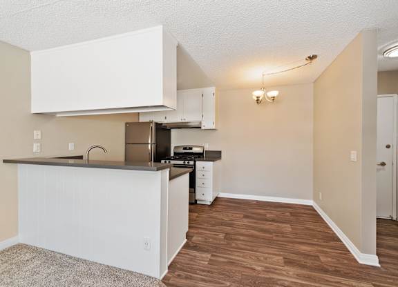 A kitchen with white cabinets and a wooden floor.at Hills at Hacienda Heights, Hacienda Heights California