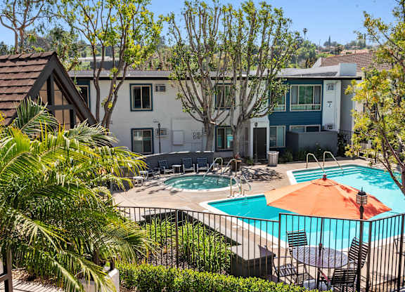 A pool surrounded by trees and a house in the background.at Hills at Hacienda Heights, Hacienda Heights, 91745