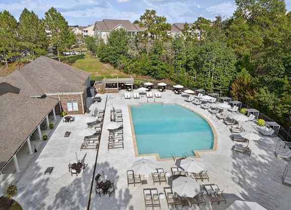 An aerial view of a pool surrounded by lounge chairs and umbrellas.