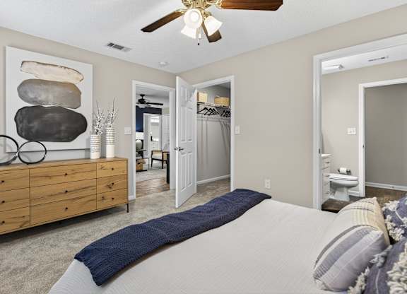 A bedroom with a large bed and a wooden dresser.
