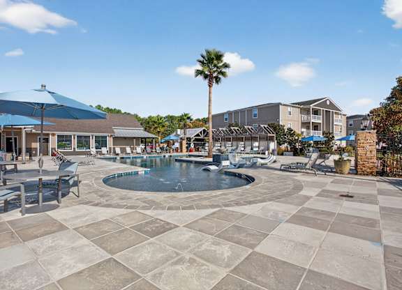 A large outdoor swimming pool surrounded by a tiled patio.
